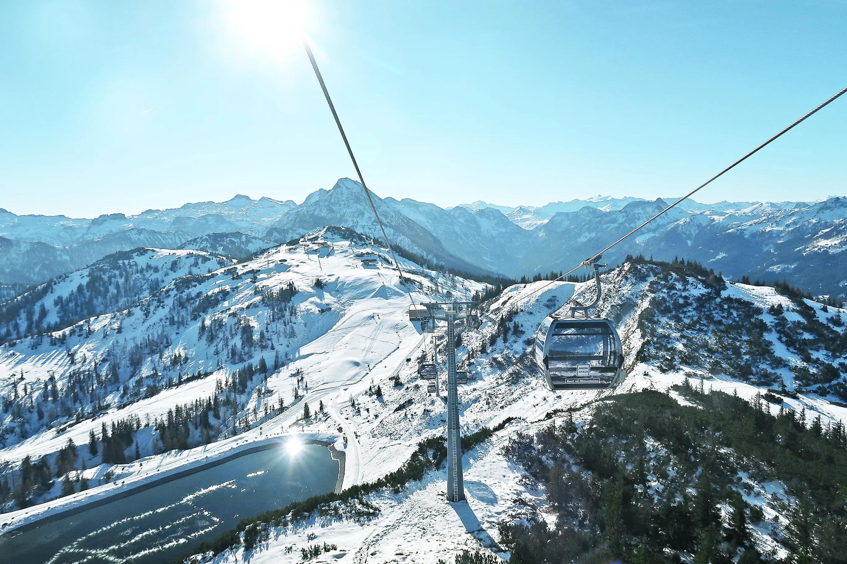 Utsikt från en skidlift i Wagrain, med panoramavy över Alperna och snötäckta berg.