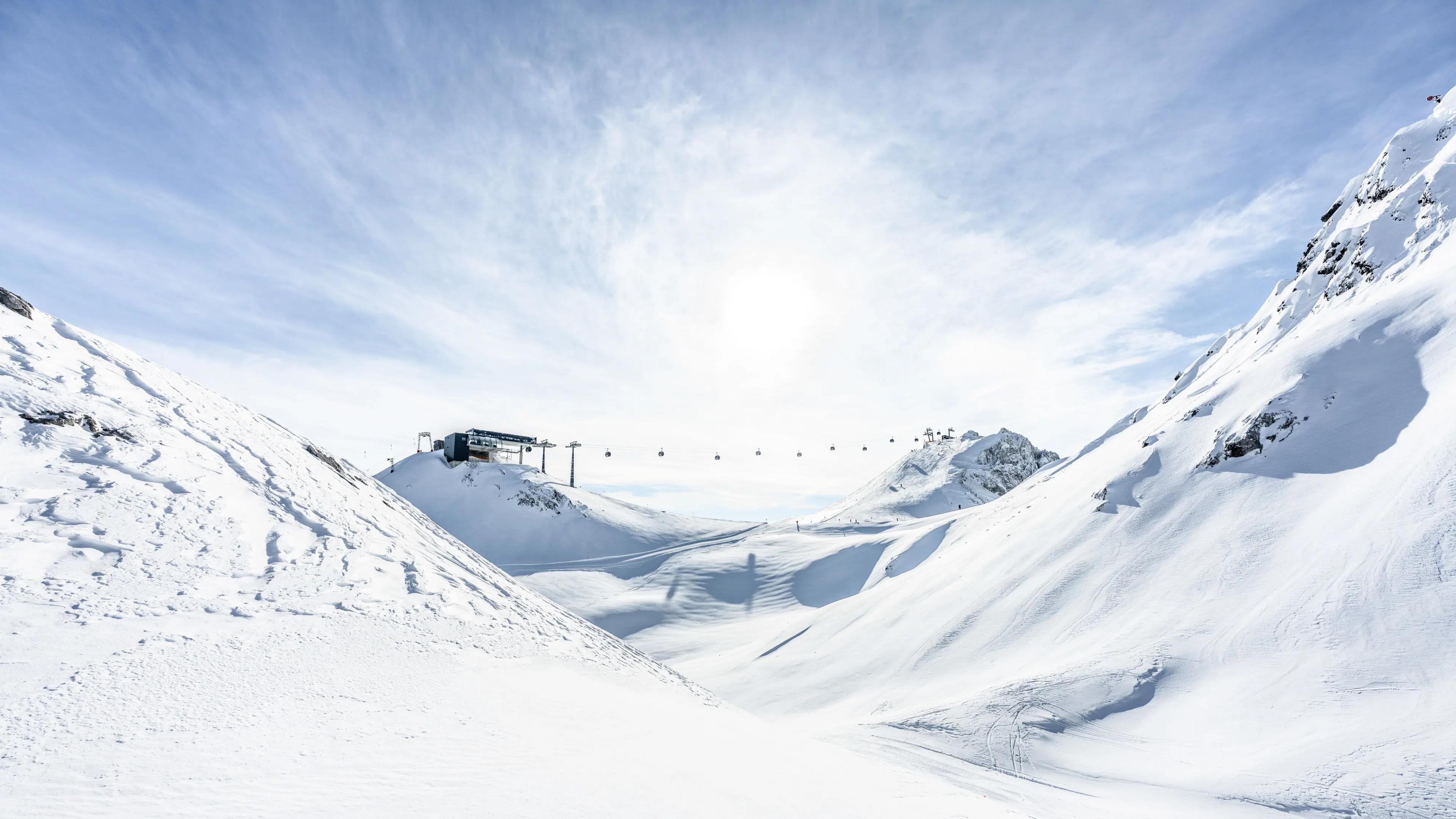 Utsikt över bergen och en lift i St. Anton, en skidort i Österrike som erbjuder fantastisk skidåkning.